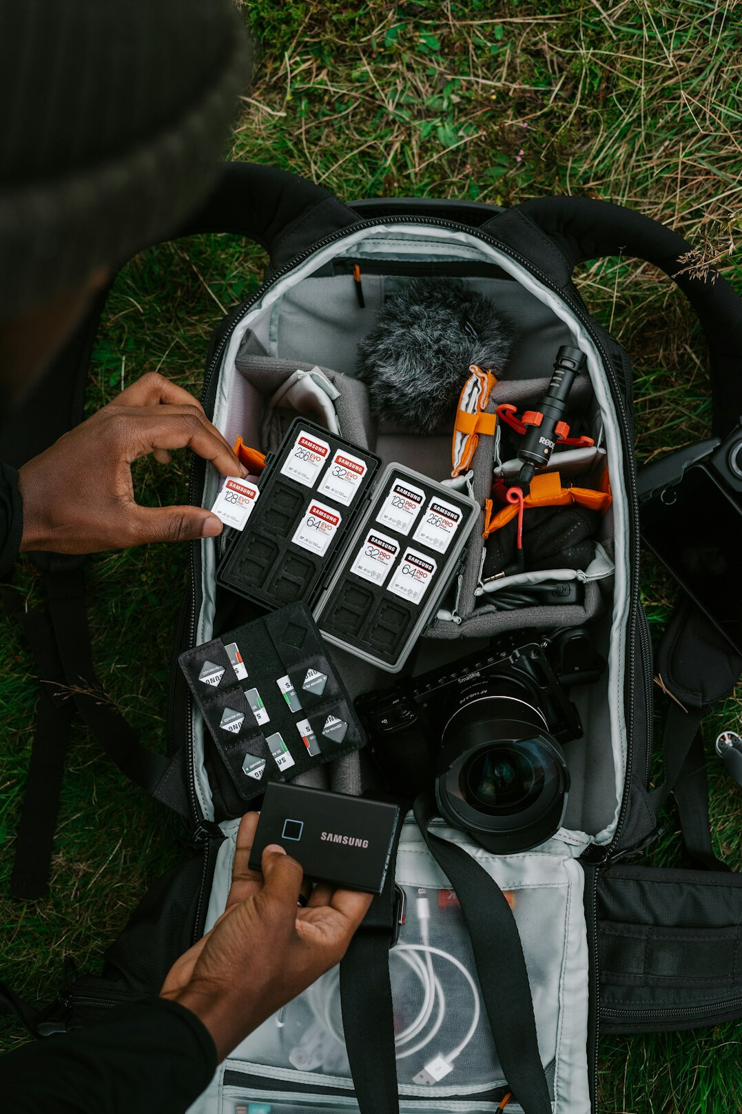 Hands preparing a professional video camera and wireless microphone kit